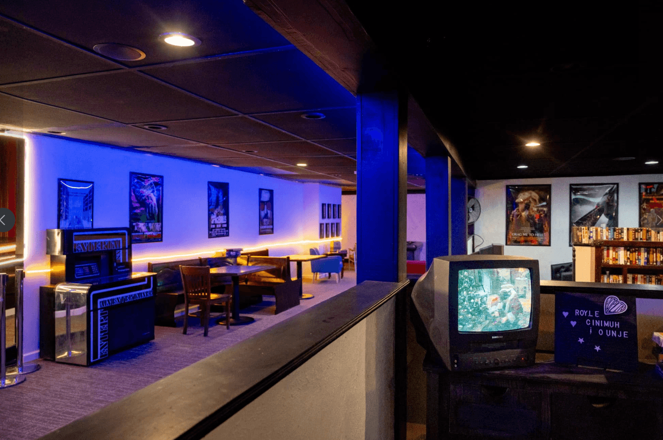 Booth seating and the film poster wall inside Royale Cinema Lounge